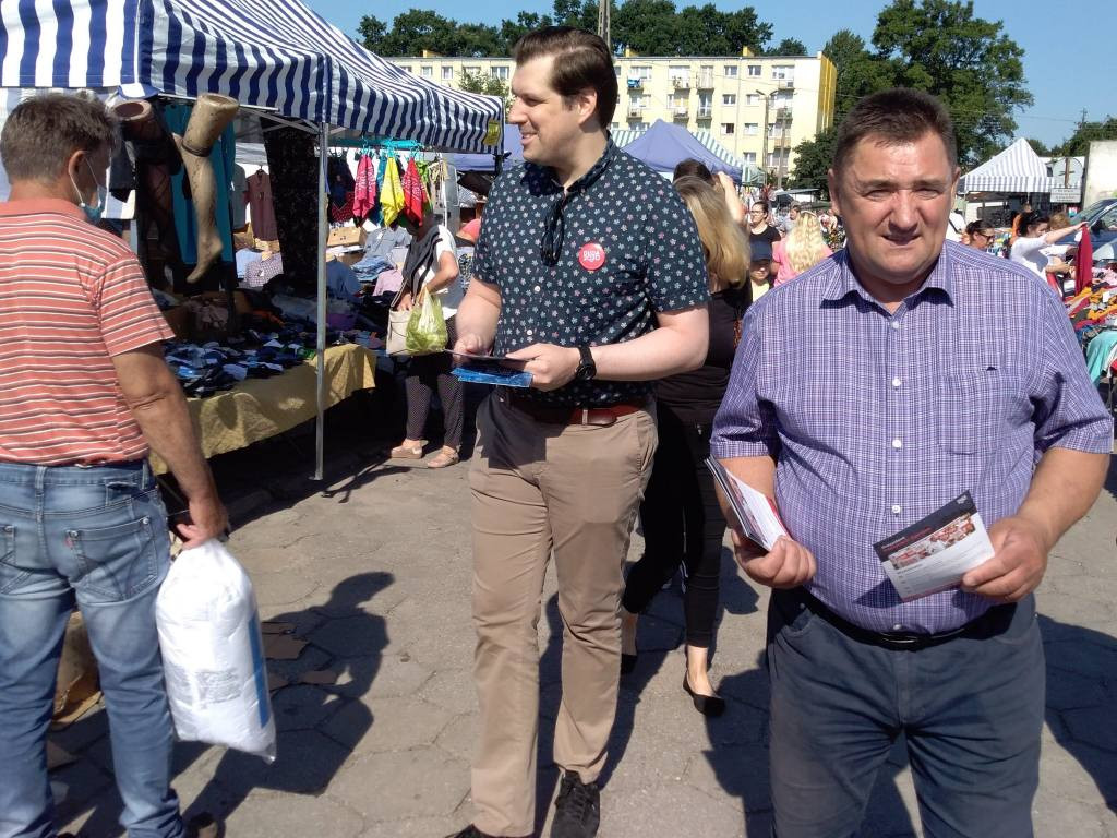 Barwy kampanii: wojewoda łódzki z ulotkami na targowisku