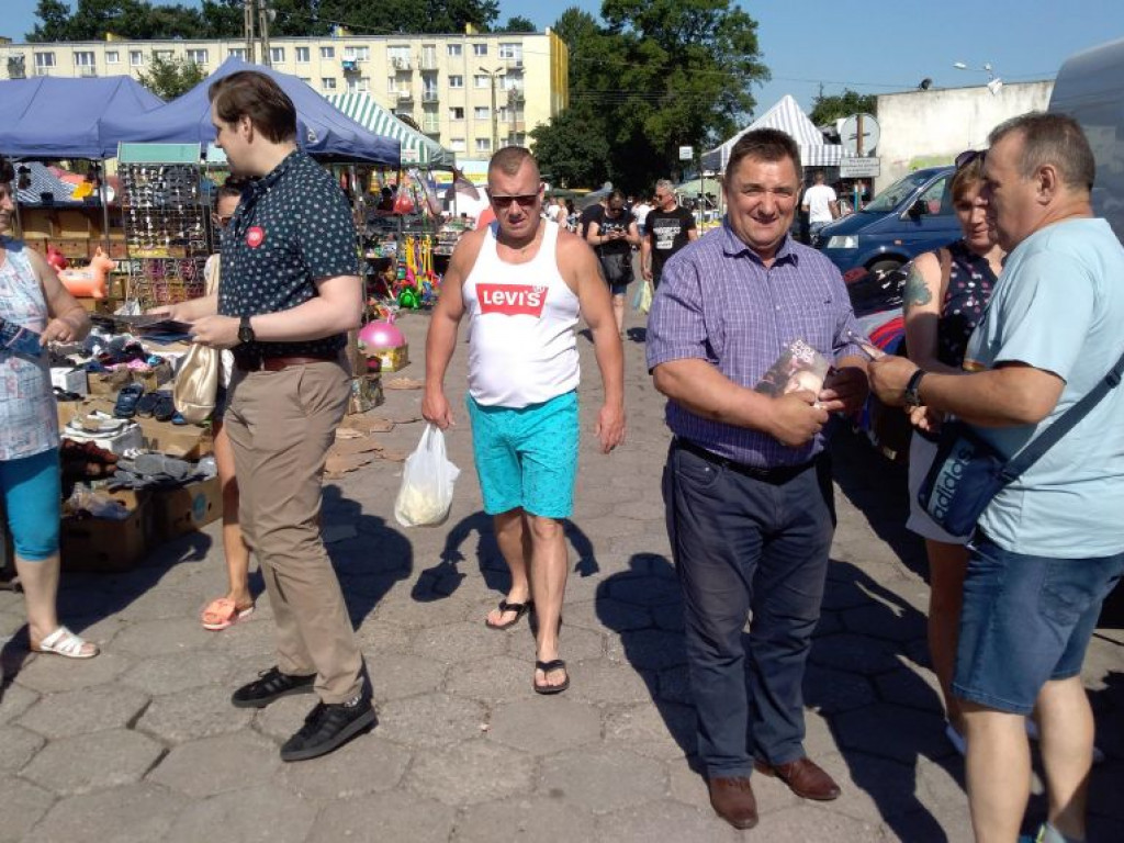 Barwy kampanii: wojewoda łódzki z ulotkami na targowisku