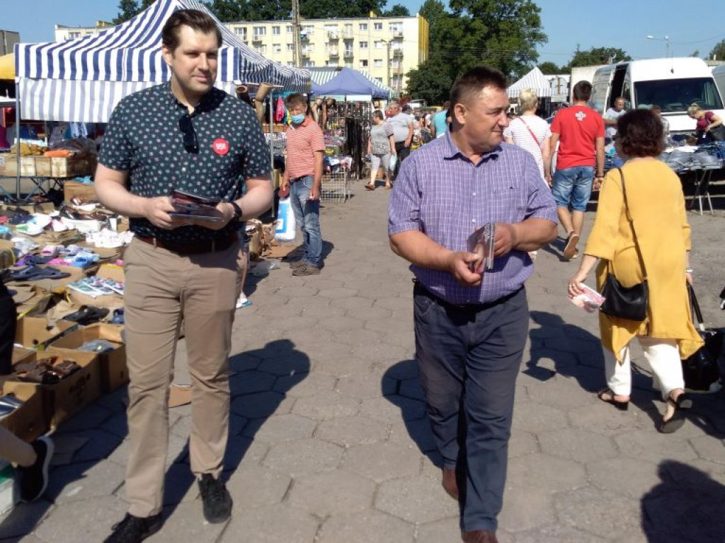 Barwy kampanii: wojewoda łódzki z ulotkami na targowisku