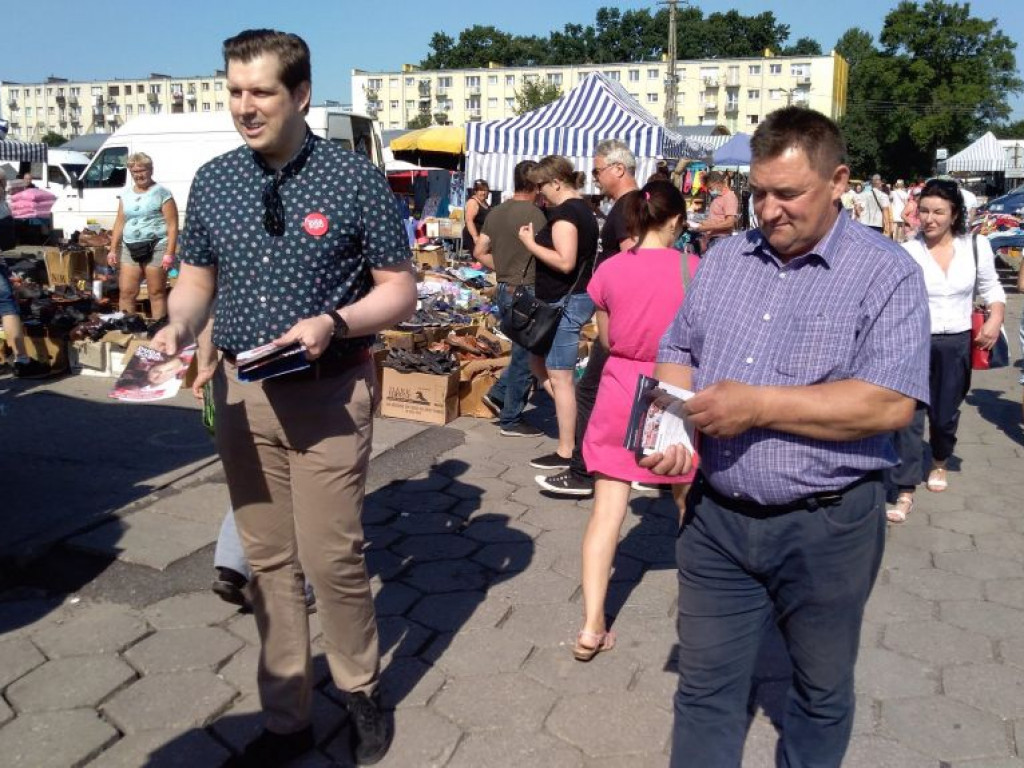 Barwy kampanii: wojewoda łódzki z ulotkami na targowisku