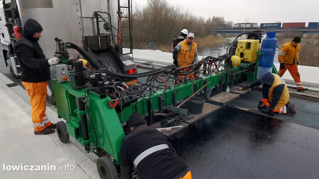 Układanie masy asfaltowej na moście w Łowiczu