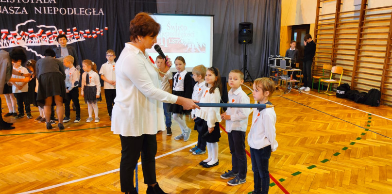 Dyrektor Wioletta Puszcz pasuje pierwszaków na uczniów Szkoły Podstawowej nr 3 w Łowiczu. 