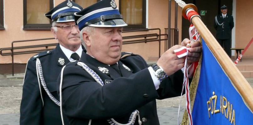 Wiesław Golański, dyrektor biura Zarządu Głównego Związku OSP RP, dekoruje sztandar jednostki OSP Bobrowniki Złotym Znakiem Związku OSP RP