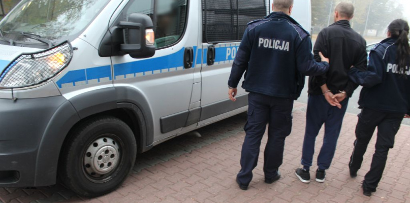 Łowicz. Policjanci doprowadzają zatrzymanego dilera do radiowozu. fot. KPP w Łowiczu.