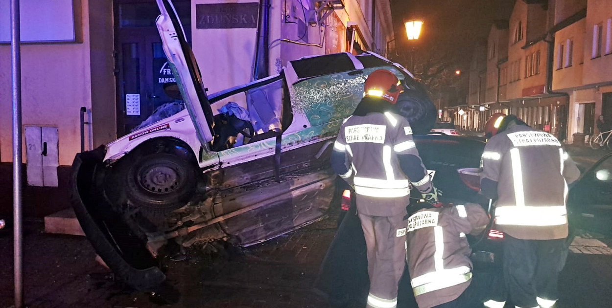 Siła uderzenia wyrzuciła fiata Pandę w górę i na ścianę narożnej kamienicy. Fot. PSP w Łowiczu